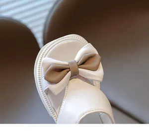 Detail der cremefarbenen Kindersandale mit schicker Schleife und weicher matter Lederstruktur