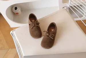 Détail de chaussures marron pour filles en daim avec nœud et semelle intérieure coeur doré