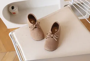 Détail de chaussures en daim kaki pour filles avec nœud papillon et doublure dorée