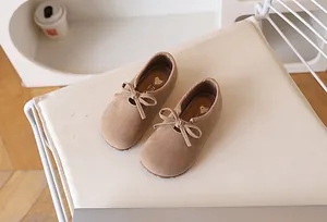 Détail de chaussures plates rétro pour filles avec nœud et semelle logo cœur doré