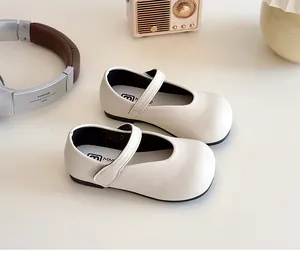 Detailed close-up of cream Mary Jane shoes with Velcro straps and smooth leather texture