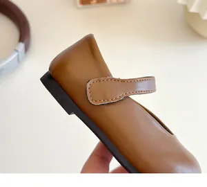 Close-up of brown Mary Jane leather shoes for girls with matte finish and stitched buckle strap