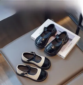 Detail of girls Mary Jane shoes in matte and patent leather with metal buckles