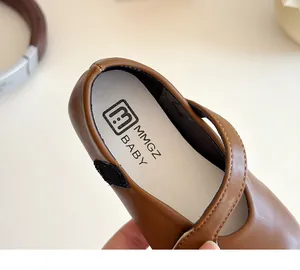 Macro shot of brown Mary Jane shoe interior showing MMGZ BABY logo and fine stitching