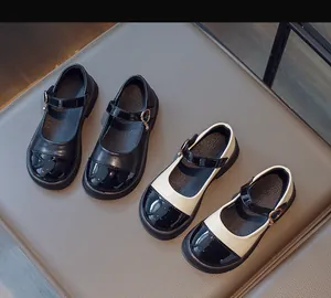 Close-up of Mary Jane shoes featuring glossy patent leather toes and gold buckle details