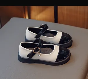 Detail of vintage black and white Mary Jane shoes for girls with rhinestone charms