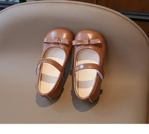 Detailed top view of brown faux leather Mary Jane girl shoes with bow and velcro strap