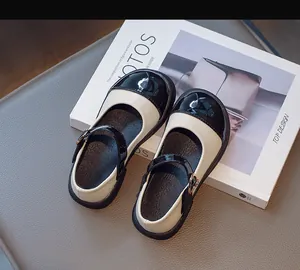Top-down view of bicolor Mary Jane shoes with black patent leather toe and cream body