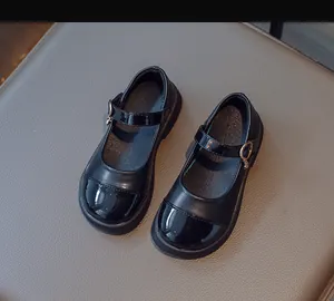 Detail of girls black Mary Jane shoes with patent leather toe and matte finish
