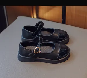Detail view of black Mary Jane shoes featuring matte leather and glossy patent stitching
