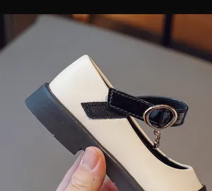 Detail of girls' Mary Jane shoes with beige matte leather and black velcro strap buckle
