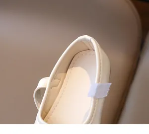 Detail view of the soft lining and fine stitching on the heel of cream girl's flats