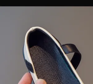 Close-up of contrast black and white girls Mary Jane shoes with Velcro strap and leather texture
