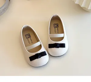 Detail von weißen Mädchen-Mary-Janes mit schwarzer Satinschleife und Gummiband