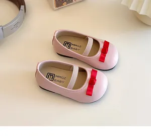 Detailaufnahme der rosa Mädchen-Prinzessin-Schuhe mit roten Satinschleifen und Gummiband
