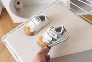 Detail of baby walking shoes with breathable white mesh, green leather and anti-slip sole