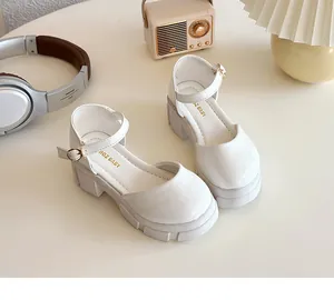 Detailaufnahme weißer Lackleder Mary Jane Schuhe mit dicker Sohle und Gold-Schnallen
