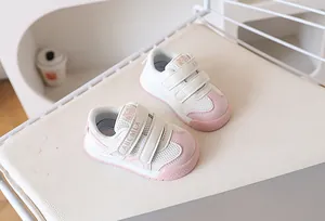 Detail of pink and white toddler sneakers featuring breathable mesh and dual velcro straps