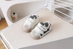Detail of baby sneakers with dual velcro straps and breathable mesh on a soft background