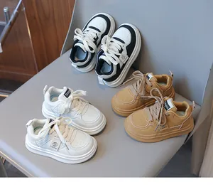 Detailed top view of three pairs of children's sneakers in black, white, and khaki colors