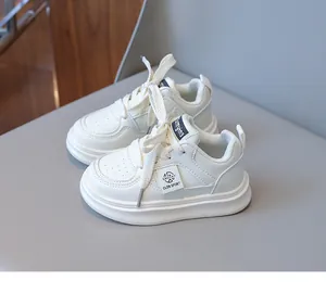 Detail view of white kids sneakers with perforated faux leather and lace-up design