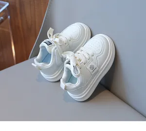Close-up of white leather kids sneakers featuring breathable perforations and stylish laces