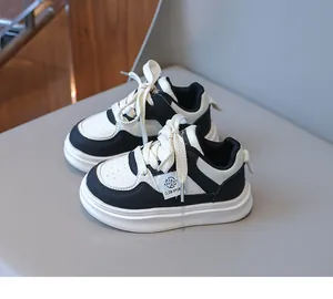 Detail shot of kids black and white panda sneakers with thick cotton laces and side labels