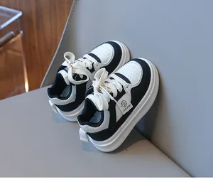 Close-up of black and white leather kids sneakers featuring CLDB SPORT logo and round laces