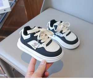 Close-up of children's black and white sneakers showing synthetic leather and mesh details