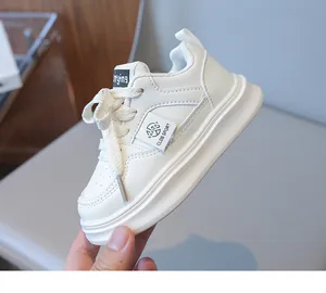 Detailed close-up of white children's sneakers showing durable synthetic leather and logo