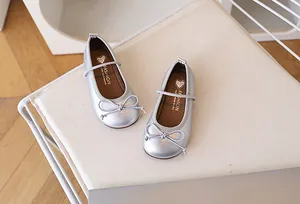 Detalle de zapatos Mary Jane plateados mate para niña con lazo y correa elástica suave