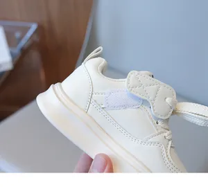 Close-up of cream children sneakers with velcro straps and durable rubber soles