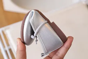 Vista macro de zapatos flexibles plateados para bebés con suela de goma suave plegable