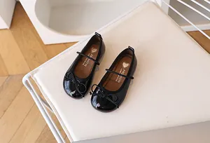 Vista superior de zapatos Mary Jane en charol negro con elegantes detalles de lazo