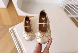 Detalle de manoletinas Mary Jane color champán para niña con lazo y acabado perlado