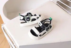 Detail van kindersportsandalen met cartoon monsterpatroon en handige klittenband