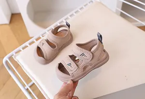 Macro view of khaki infant sandals with dual hook-and-loop straps and star patterns