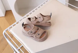 Detailed view of brown toddler sandals with adjustable velcro straps and star pattern