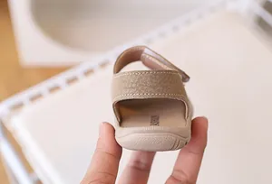 Close-up of beige baby sandals featuring secure velcro heel strap and soft inner sole
