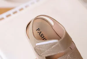 Macro shot of beige baby sandals featuring adjustable velcro strap and soft suede texture
