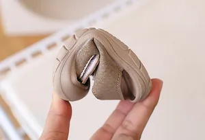 Detail showing the ultra-flexible soft rubber sole of khaki baby shoes being folded