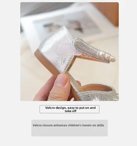 Dettaglio dei sandali argentati glitterati da bambina con perle e chiusura a strappo