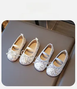 Detail of ballet flats showing sparkling sequins, bow accents and elastic straps