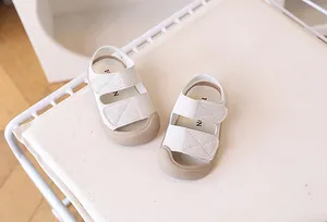 Close-up of off-white toddler sandals with dual velcro straps and anti-collision rubber toes