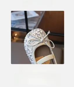 Detailed macro view of silver sequin ballet flats with bow and elastic strap