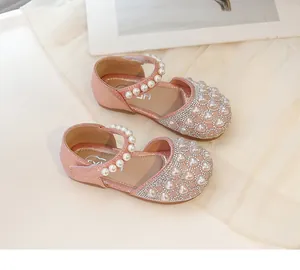 Dettaglio di scarpe Mary Jane rosa glitterate con perle a cuore e strass luccicanti