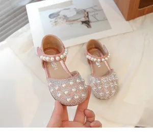 Dettaglio di sandali rosa glitterati per bambine con perle a cuore e strass luminosi