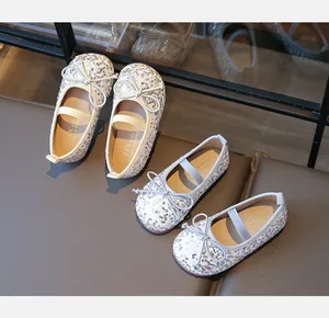 Macro detail of sparkly sequin Mary Jane shoes with delicate bow and elastic strap
