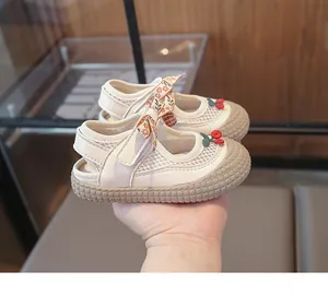 Détail de sandale enfant en mesh respirant avec breloque cerise et nœud floral chic