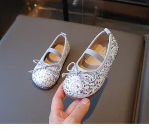 Close-up of silver sequin ballet flats for girls with bow detail and elastic strap